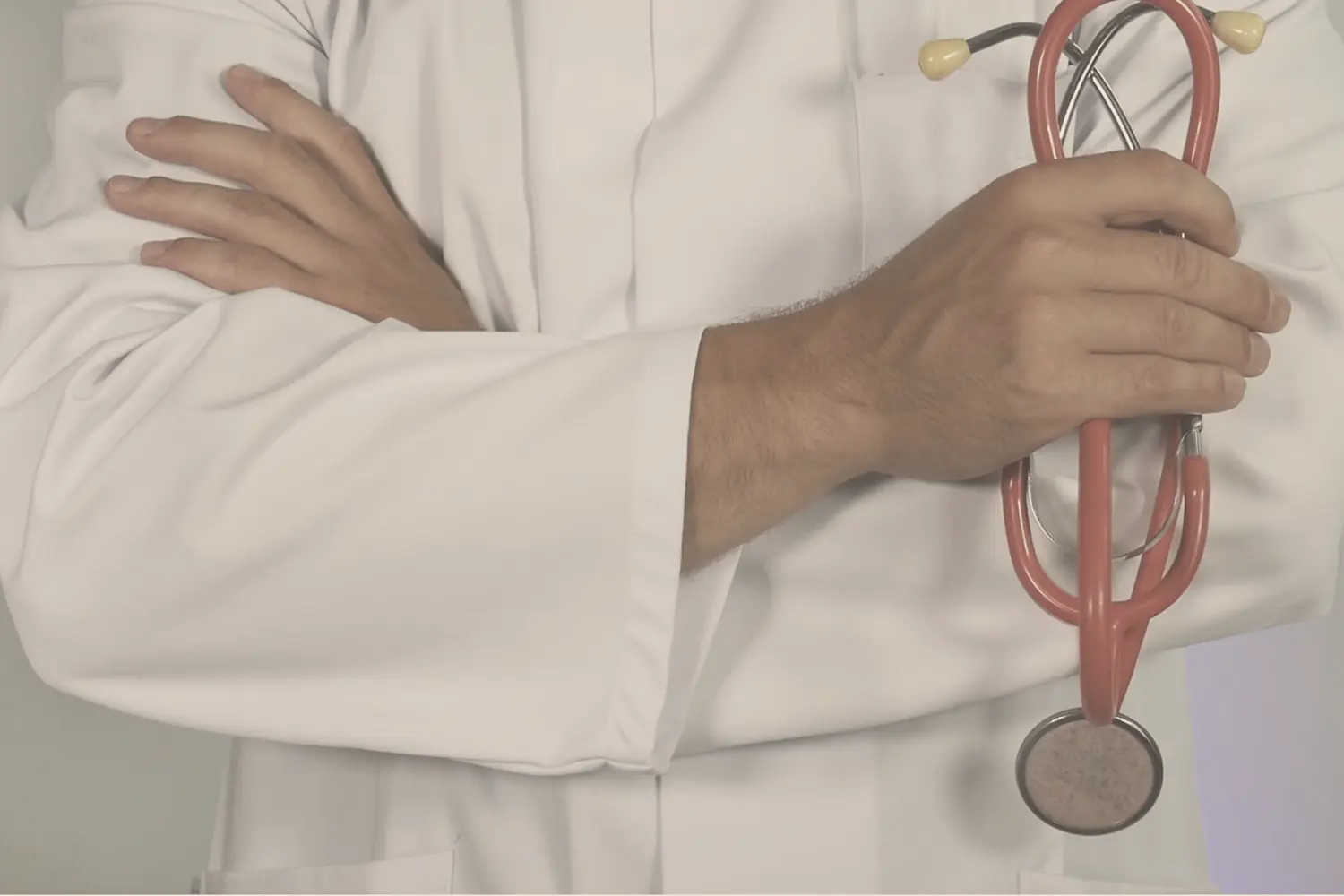 A clinician with a stethoscope, arms folded