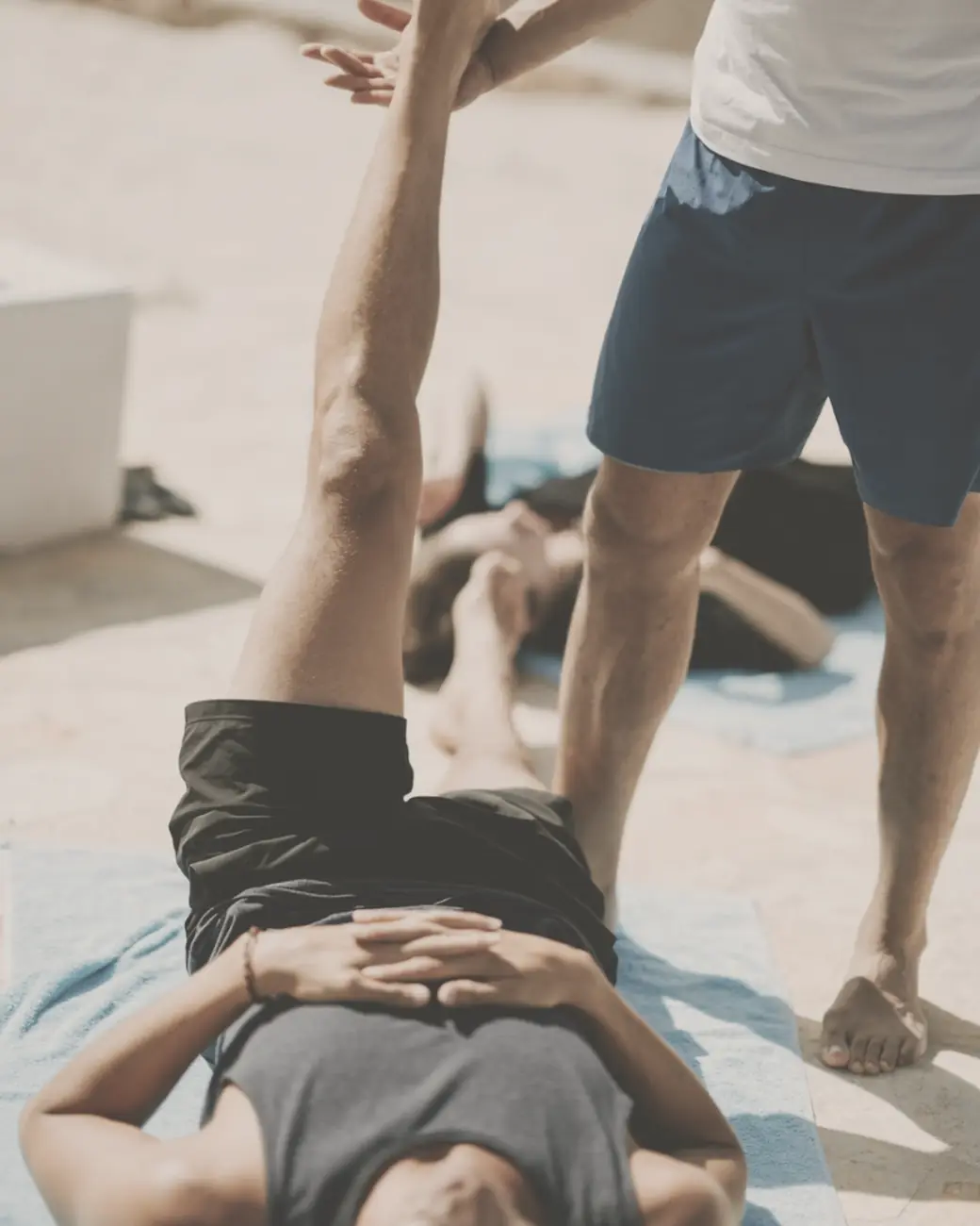 A coach assisting a client with a guided stretch